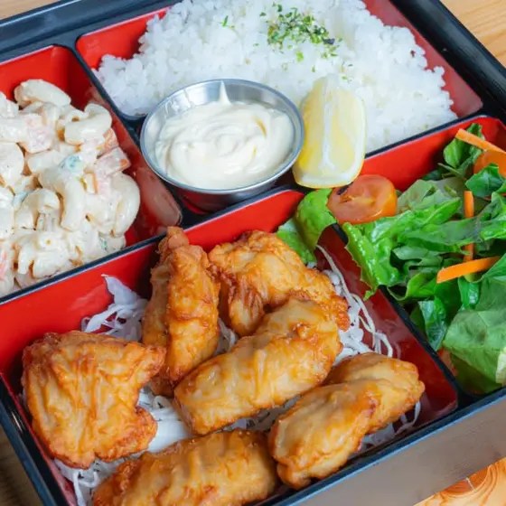 Chicken karaage bento box with rice, salad, and macaroni salad.