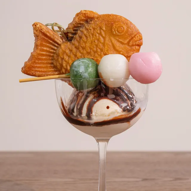Taiyaki sundae: a fish-shaped waffle and dango skewer on chocolate soft serve.